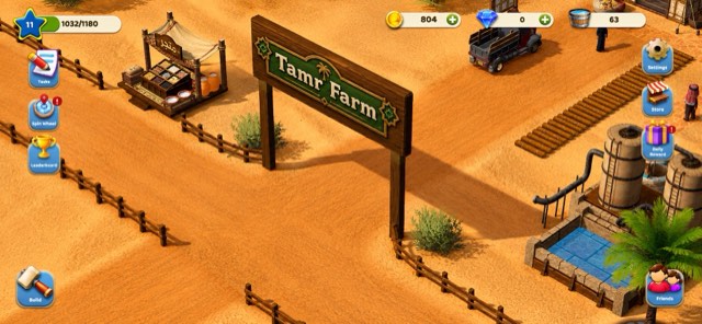 بوابة خشبية كُتب عليها «Tamr Farm» في شمس مائلة، وبجوارها بسطة وشاحنة وخزّانا ماء عند حوض.